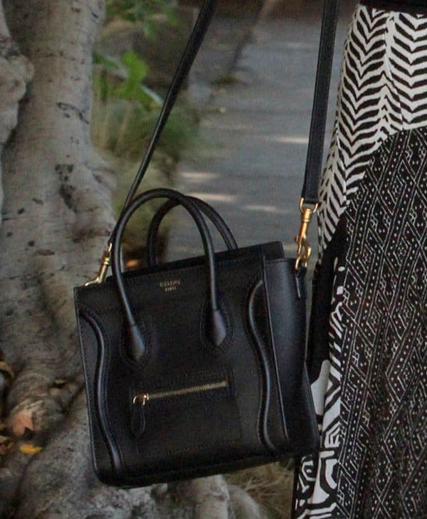 Ashley Tisdale accessorizes with a sleek black Céline Nano Luggage Tote, featuring structured handles, gold-tone hardware, and the brand’s signature front zip pocket