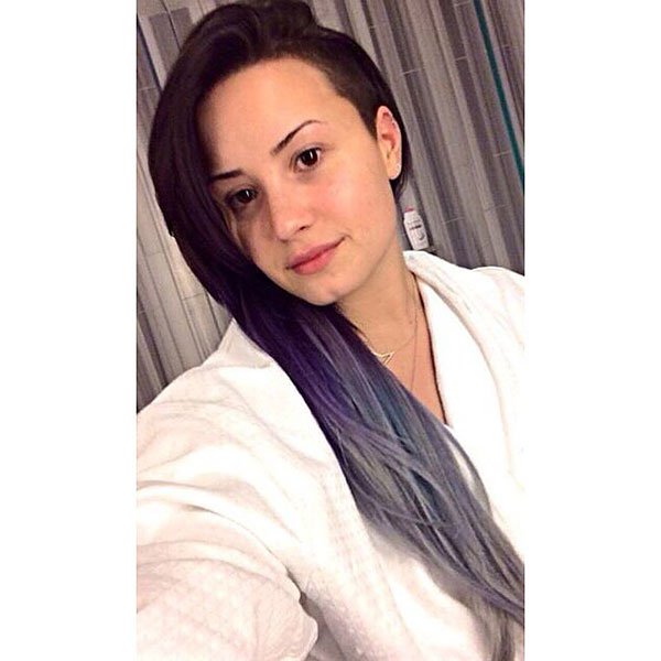 Demi Lovato embraces a natural look, showing off her lavender and silver ombre hair while relaxing in a cozy bathrobe