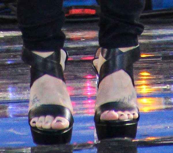Demi Lovato's edgy look is complemented by a fresh pedicure and delicate foot tattoos