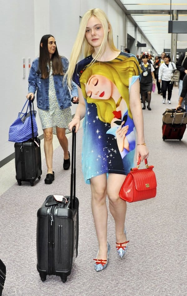 Elle Fanning stuns in a vibrant Princess Aurora t-shirt dress by Romance Was Born, capturing her inner Disney princess