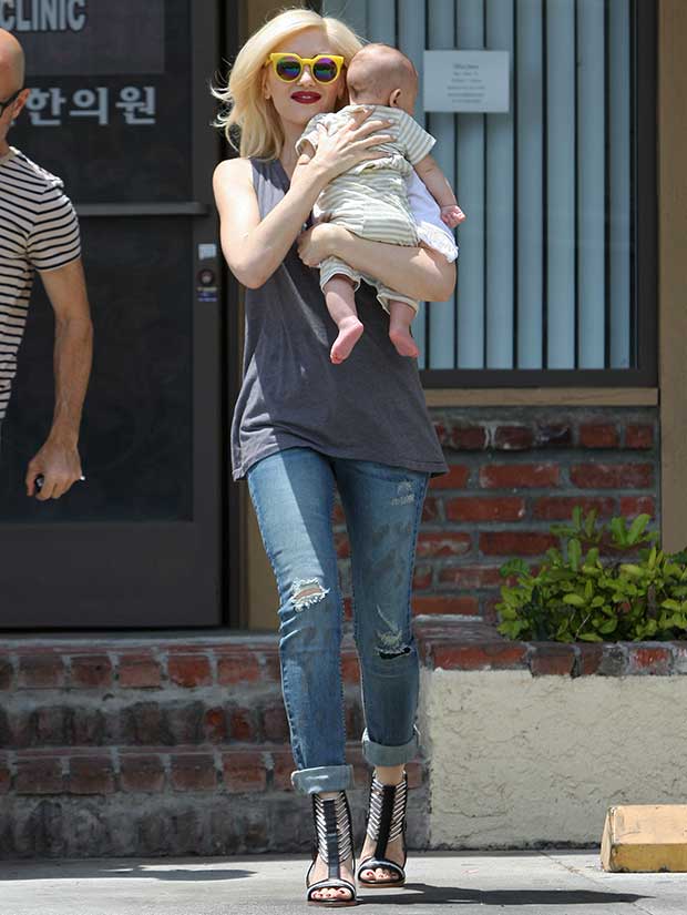 Recreate Gwen Stefani's effortlessly chic look with a loose gray tank, cuffed distressed jeans, bold yellow sunglasses, and fierce strappy black heels for a statement-making ensemble