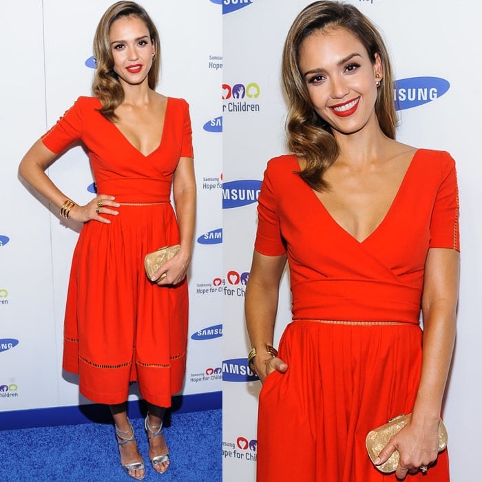 Jessica Alba brightened the Samsung Hope for Children Gala in a vivid red-orange Preen dress, pairing the saturated color with reflective Brian Atwood sandals, stacked Jill Golden jewelry, and a shimmering Corto Moltedo clutch for a warm metallic finish