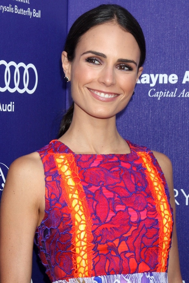 Jordana Brewster styled her hair in a sleek low ponytail, keeping the focus on her flawless makeup, which featured bold purple eyeshadow and a glossy pink lip
