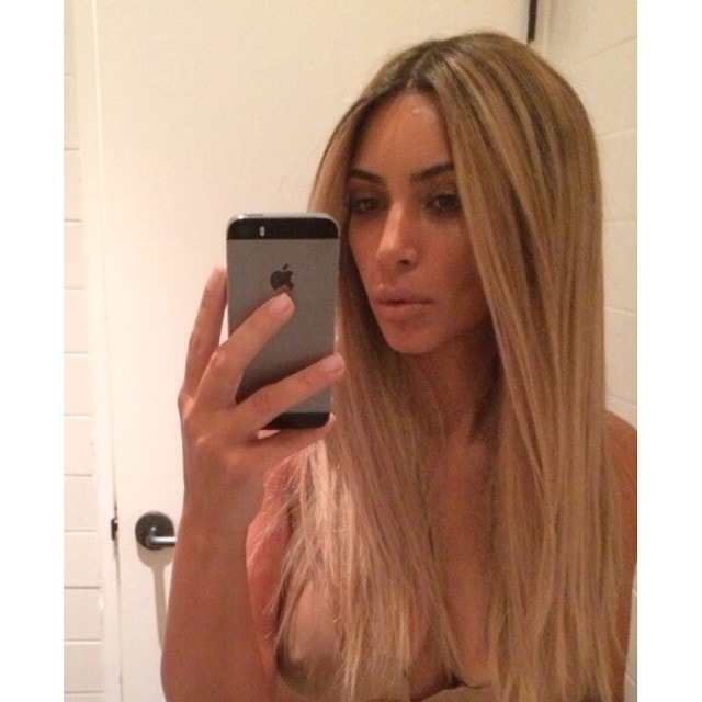 Kim Kardashian posts a mirror selfie on Instagram on June 26, 2014, unveiling what she called a hyper-realistic blonde wig—though the sheer, barely-there styling resulted in a visible nipple that quickly overshadowed the hair reveal and fueled widespread attention