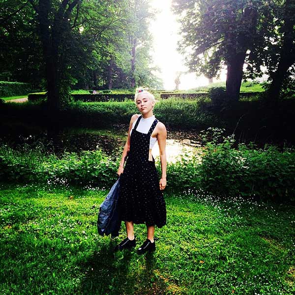 Miley Cyrus wears a Comme des Garçons printed dress with a Topshop skinny polo crop top and Comme des Garçons platform sneakers