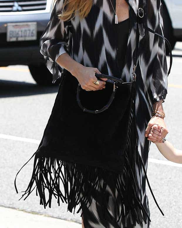 Rachel Zoe accessorizes her black-and-white maxi dress with a fringe Gucci shopper bag and chic gold jewelry, embodying effortless bohemian style