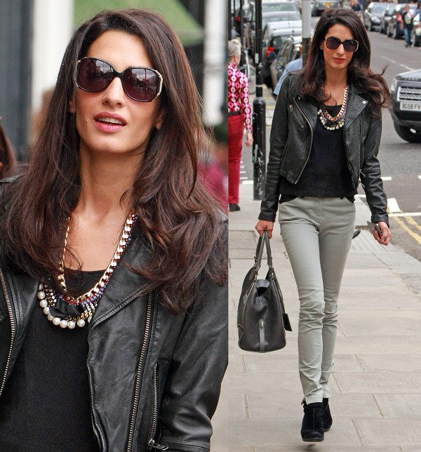 Amal Alamuddin is seen sporting a stylish biker chick look, featuring a sleek black leather biker jacket paired with a black top, light grey skinny jeans, and black suede ankle boots