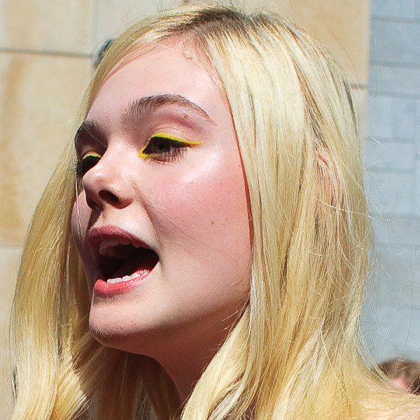A closer look at Elle Fanning’s playful beauty choice, featuring bright yellow eyeliner that echoes the youthful energy of her coral lace ensemble