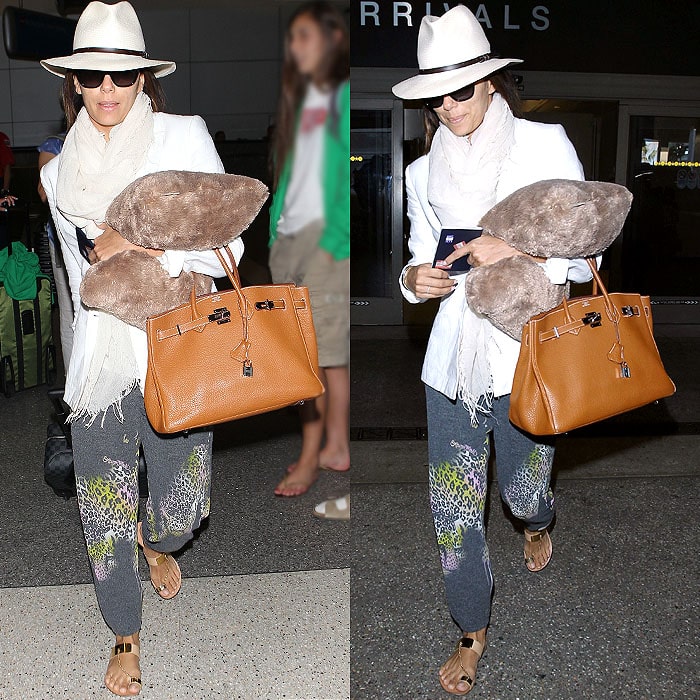 Eva Longoria elevates her casual Lauren Moshi sweatpants with a tailored blazer, Hermes Birkin handbag, and chic gold sandals at LAX