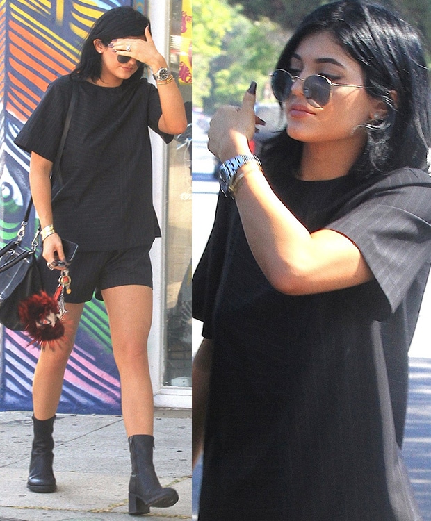 Kylie Jenner steps out on Melrose Avenue in a chic monochrome outfit featuring an Alexander Wang pinstriped tee and shorts, accessorized with Ray-Ban sunglasses and Ann Demeulemeester boots