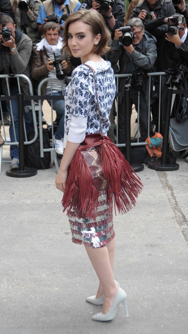 Lily Collins accessorized with a matching scarlet bag and white stiletto heels at the Chanel Show