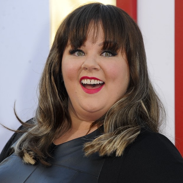 Melissa McCarthy in a midi-length dress featuring a light layering of whisper-thin chiffon and a leather front