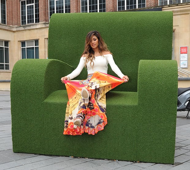 Perched playfully on an oversized green chair outside ITV Studios, Nicole Scherzinger flashes her colorful Dries Van Noten platforms—an artful mix of snake-stamped leather, embroidery, and sculpted wooden heels