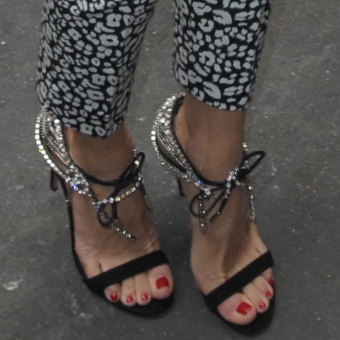 A close-up of Olivia Palermo's crystal-embellished lace-up sandals paired with her mixed-print pants at Paris Fashion Week