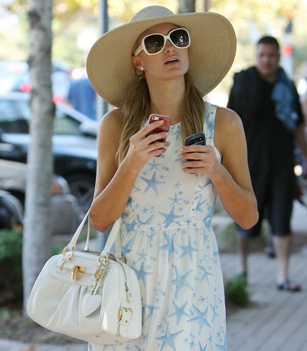 Paris Hilton shows off her white handbag and Prada sunglasses