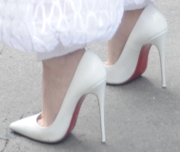 Kristen Stewart completes her look with classic white Christian Louboutin "So Kate" pumps, featuring the signature red soles