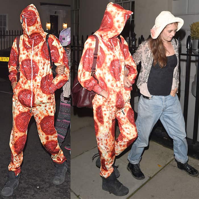 Cara Delevingne hides beneath a pepperoni pizza-print jumpsuit while stepping out in London, pairing the playful one-piece with black wedge sneakers and a burgundy shoulder bag
