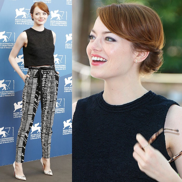 Emma Stone exudes effortless style in a black crop top, black and white printed pants, and white pointed-toe heels, complemented by her sleek auburn updo