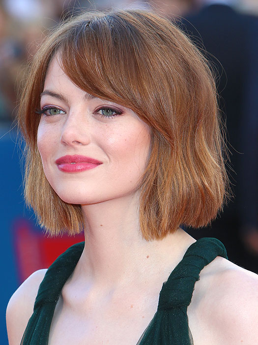 Emma Stone rocks a stylish bob haircut in a warm, honey-toned auburn color, beautifully framing her face and enhancing her natural features