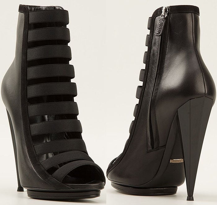 The Gucci “Olimpia” elastic-strap cage booties feature stacked stretch bands, a peep-toe silhouette, and a sharp stiletto heel for a bold, architectural finish