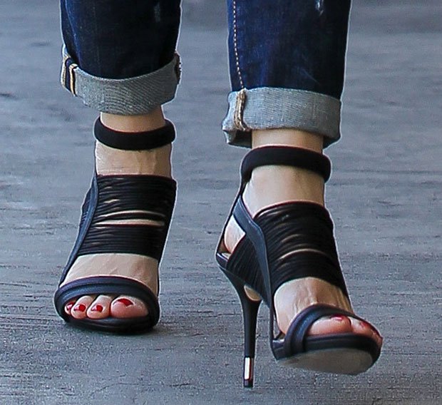 The GX by Gwen Stefani Haru sandals feature a bold strappy design, ankle straps, and metallic-capped stiletto heels