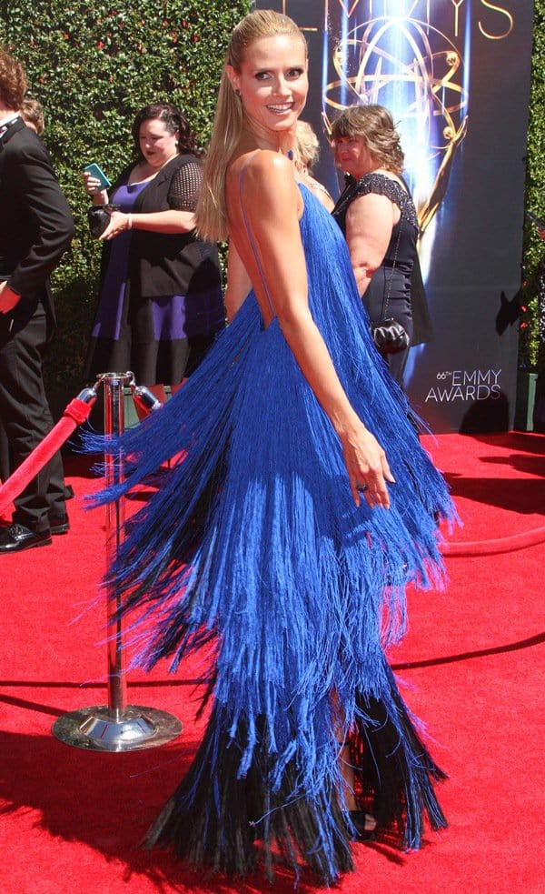 Turning over her shoulder on the red carpet, Klum lets the fringe ripple outward, the monochrome styling—from sapphire jewelry to black platforms—keeping the focus on texture and motion