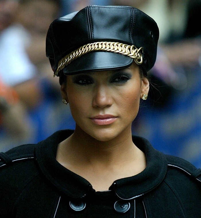 Jennifer Lopez adds a bold edge to her look with an SM-inspired black leather cap featuring a striking gold chain detail