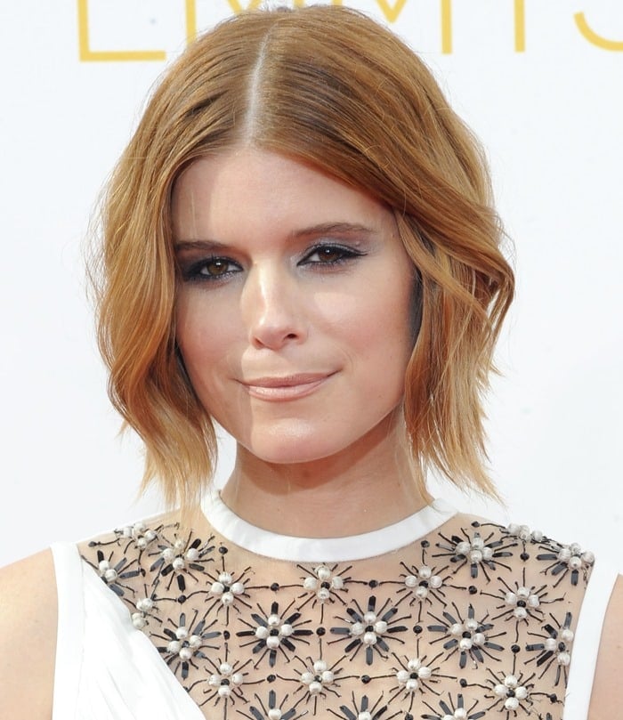 Kate Mara posing on the red carpet in her white layered J. Mendel gown at the 66th Primetime Emmy Awards in Los Angeles