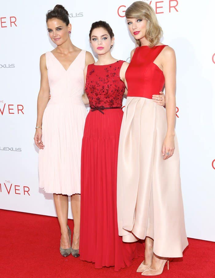 Katie Holmes, Odeya Rush, and Taylor Swift radiated complementary elegance at The Giver premiere—Holmes in soft blush pleats, Rush in rich red embroidery, and Swift in a sleek two-tone gown paired with nude pointed-toe pumps