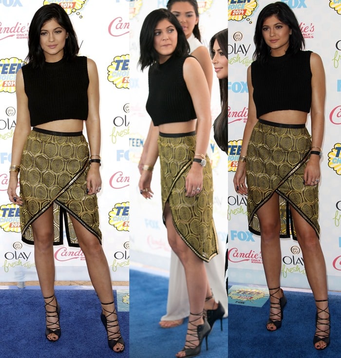 Kylie Jenner at the 2014 Teen Choice Awards, wearing a gold-and-black printed wrap skirt from Sass Bide paired with a black cropped top and Malone Souliers lace-up sandals