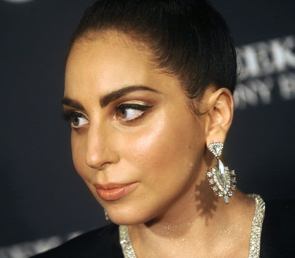 Lady Gaga accessorized her black Alon Livné caftan gown with oversized BaubleBar “Crystal Xena” drop earrings featuring faceted stones and dramatic chandelier detailing