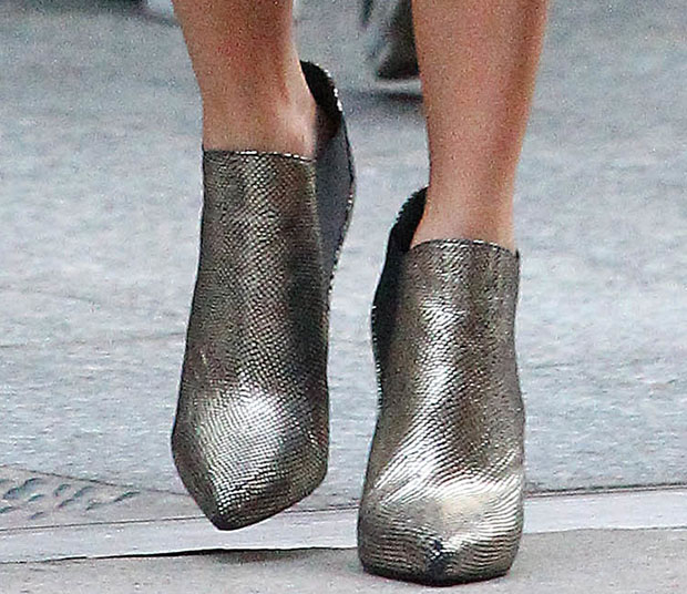 A close-up highlights Reed’s metallic ankle booties, where pointed toes and a subtle platform add sharp contrast to an all-black outfit