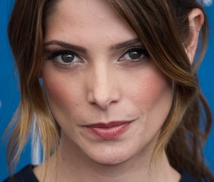 Ashley Greene exudes soft glamour with neutral makeup and a loose, side-swept hairstyle