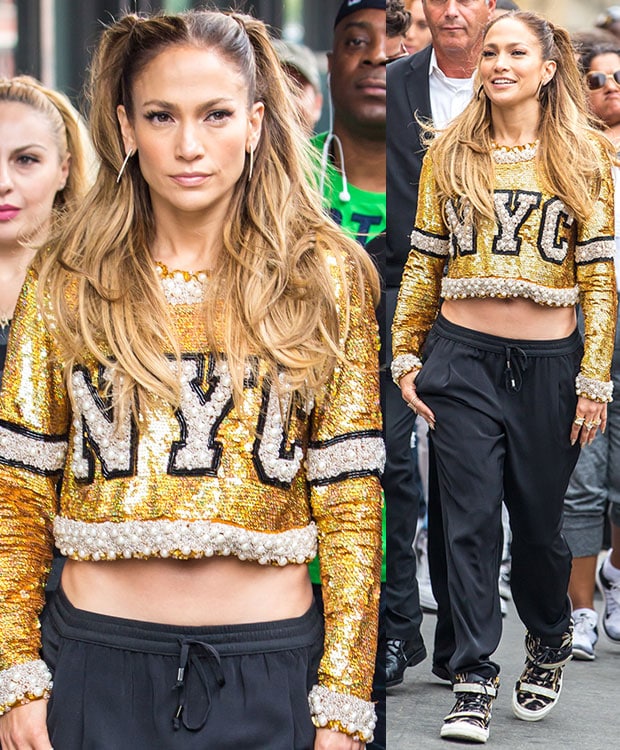 For a high-fashion take on streetwear, Lopez pairs a shimmering gold "NYC" crop top with relaxed black drawstring trousers and designer sneakers