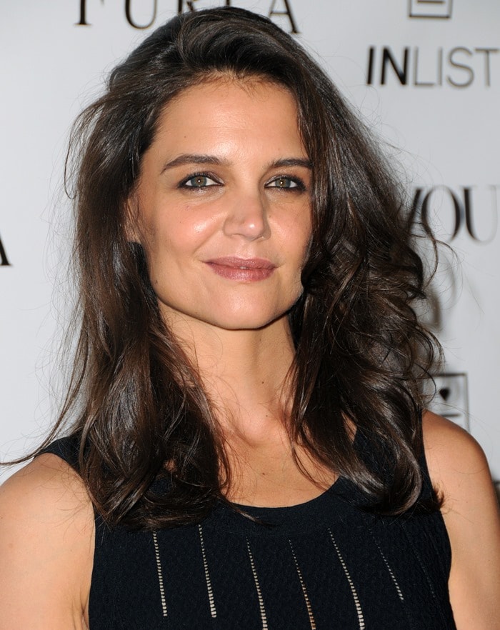 Katie Holmes in a black stretch-knit dress by Azzedine Alaïa featuring ladder-effect vertical stripes