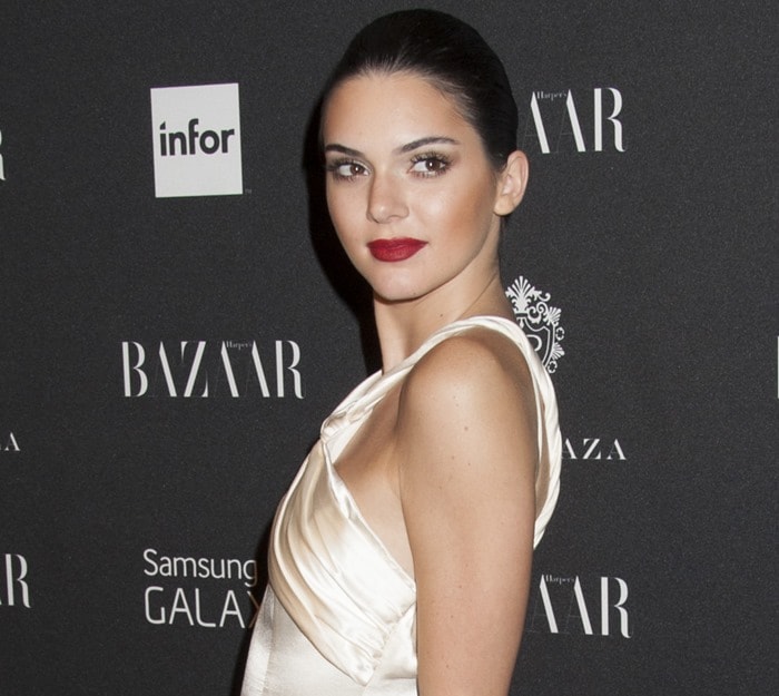 Radiating effortless confidence, Kendall Jenner pairs bold red lips with an ivory satin gown at Harper’s Bazaar’s Icons by Carine Roitfeld party in New York City