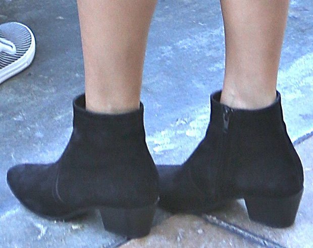 Kourtney Kardashian completed her boho-chic look with classic black suede ankle boots featuring a modest block heel and side zippers, adding both comfort and style to her maternity outfit