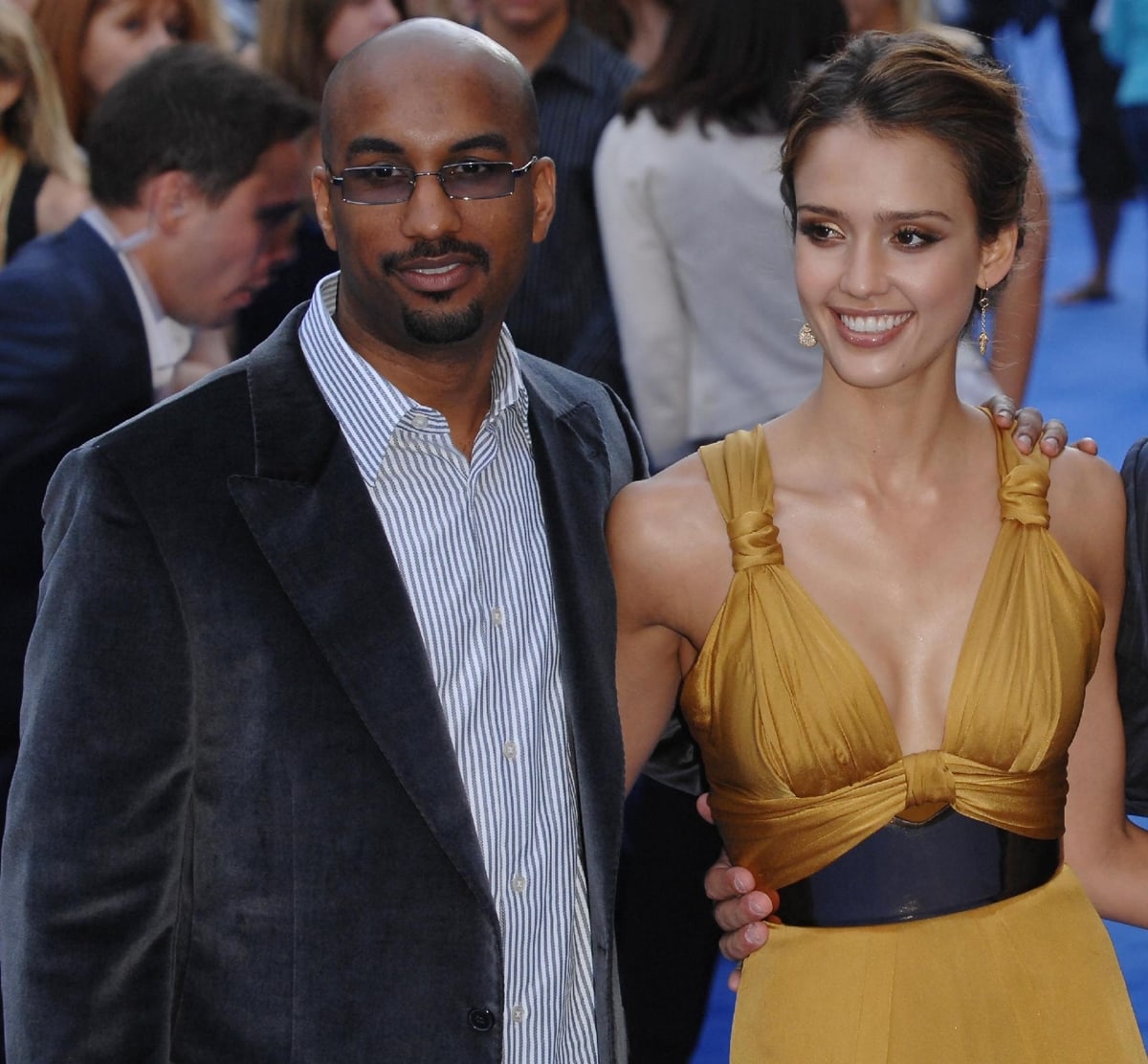 Jessica Alba exudes glamour in a golden halter gown cinched with a black belt, attending the London premiere of Fantastic Four: Rise of the Silver Surfer alongside director Tim Story