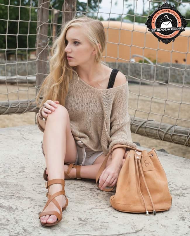 Ewa rocks a chunky sweater with linen shorts, strappy flat sandals, and a rope-like bracelet