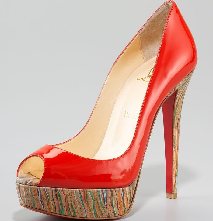 This bold red patent-leather “Banana” pump stands out with its sculptural peep toe and a vibrant marbled cork platform that adds a playful twist to the towering heel