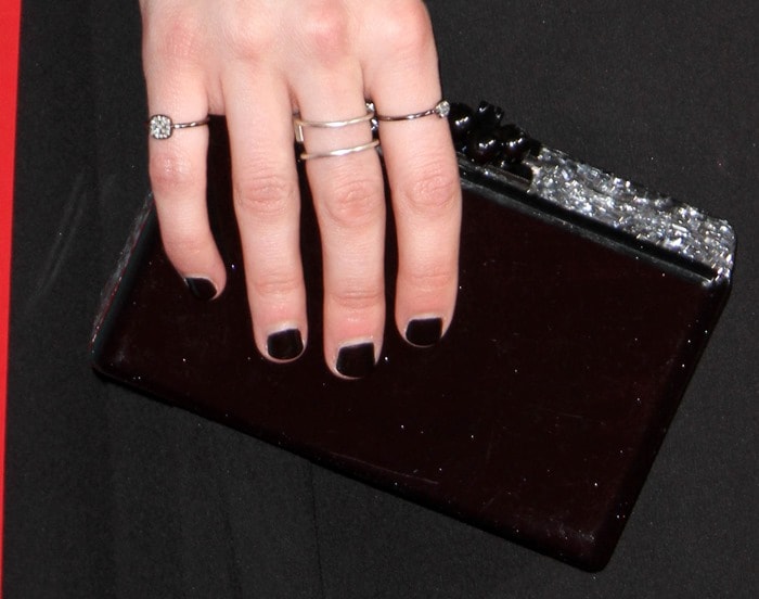 Emma Roberts totes an Edie Parker acrylic clutch and shows off her Meredith Marks rings