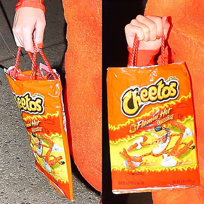 Katy Perry completes her Flamin' Hot Cheetos costume with a matching Cheetos bag for treats at Kate Hudson's Halloween party in 2014