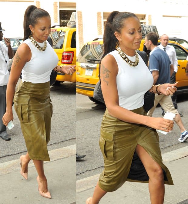 Mel B pairs a sleek olive-green slit skirt with a white tank top and a statement necklace, creating a stylish and balanced look in New York City