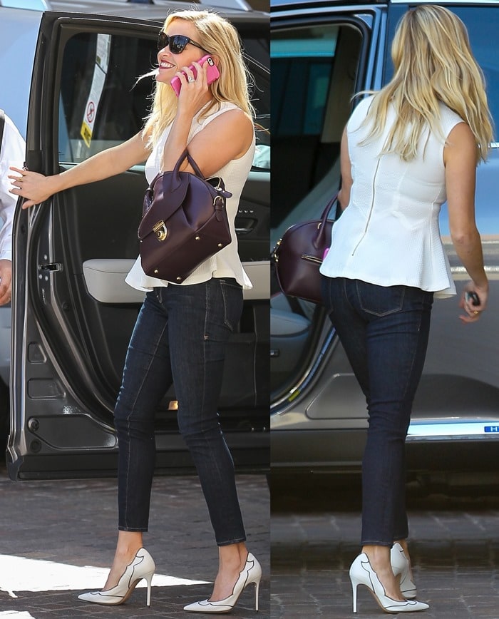 Reese Witherspoon looking well dressed in a peplum top and jeans while talking on her cell phone outside a medical center in Santa Monica on October 2, 2014