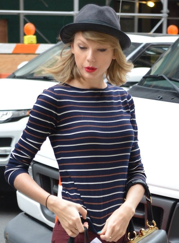 Taylor Swift wearing a striped Demylee sweater and a black fedora by Rag Bone