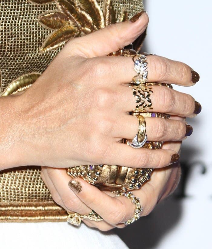 Jessica Alba showcases her elegant rings and a matching Brian Atwood clutch, complemented by her gilded nails