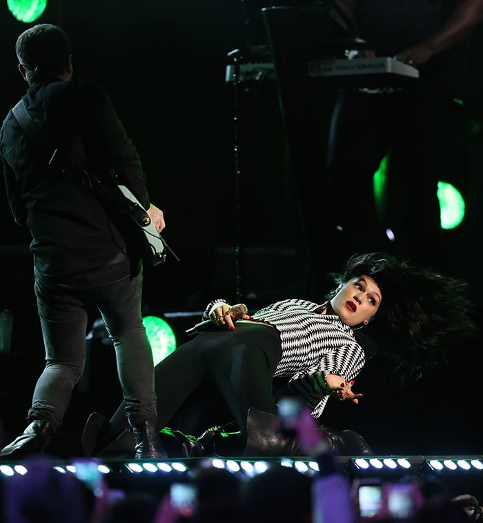 Jessie J takes her performance to the next level, dramatically lying down on stage while keeping the energy alive in her bold black-and-white ensemble and sleek stiletto boots