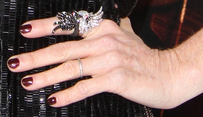 Julianne Moore flaunts a striking double-finger wing ring encrusted with black and white diamonds, styled with a sleek burgundy manicure