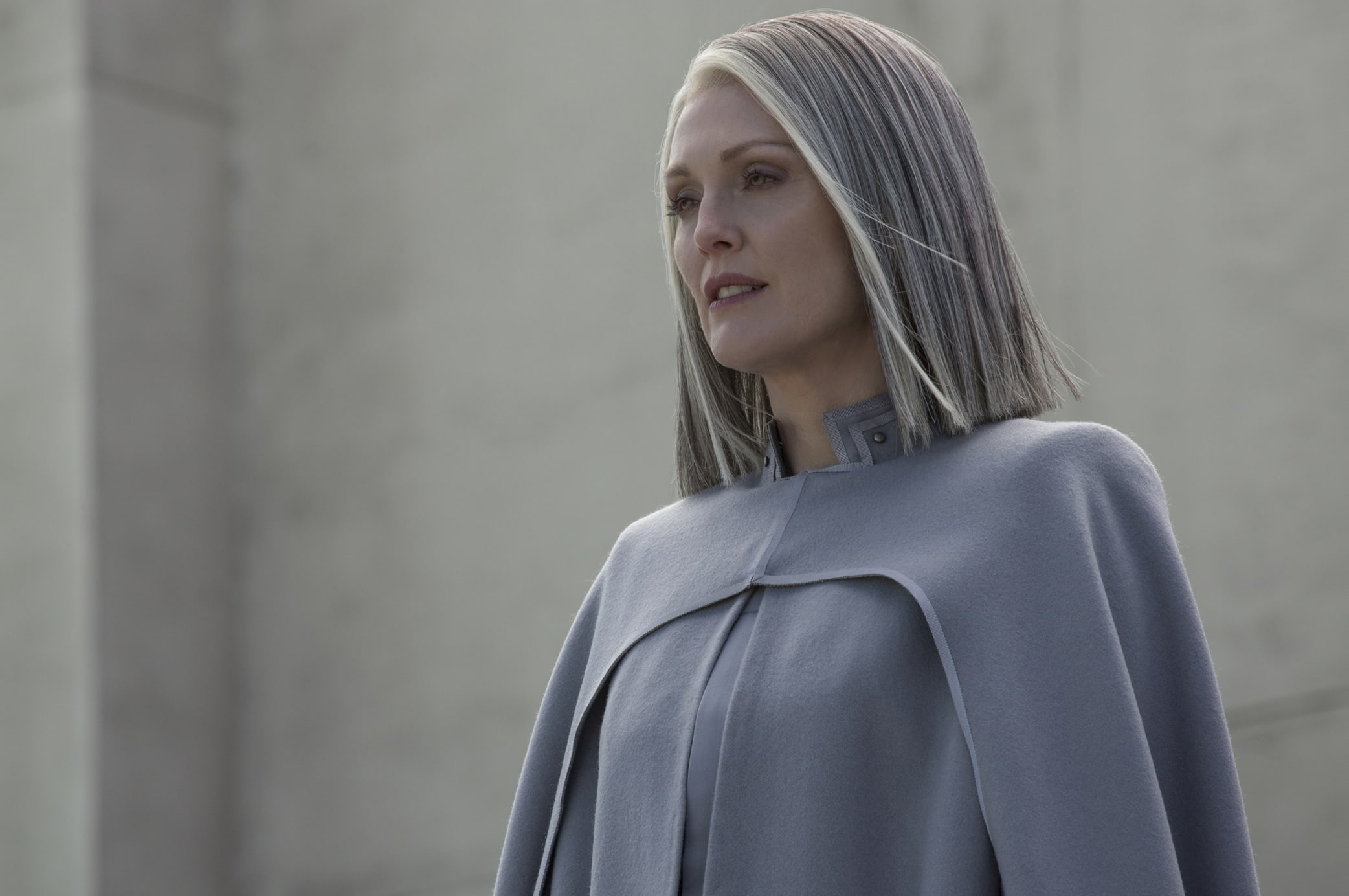 Julianne Moore portrays the authoritative and strategic President Alma Coin in The Hunger Games: Mockingjay – Part 1, donning her character's signature grey ensemble