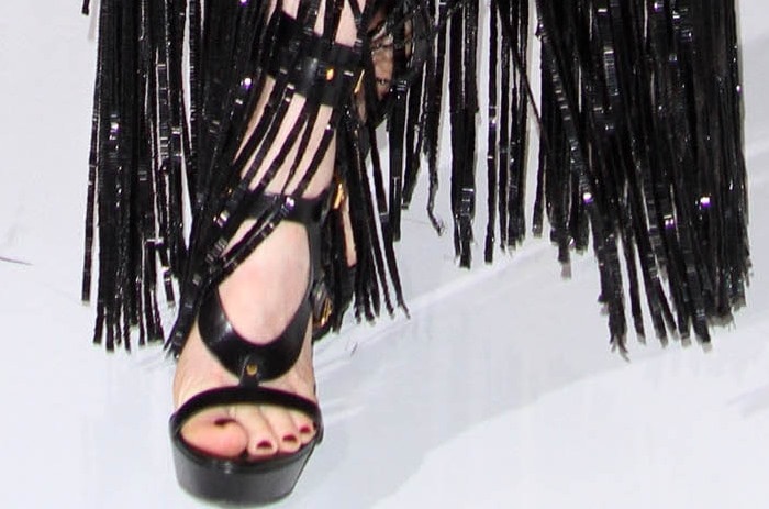 Julianne Moore flaunts a bold pedicure and adds height in sleek black platform sandals from Tom Ford, perfectly complementing the fringe detail of her dramatic gown